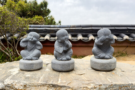 Three wise little monk stone statues representing see, hear and speak no evil philosophy