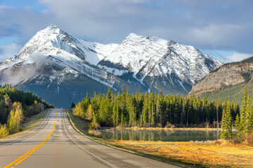 Fototapeta premium Mountain highway beside forest and reflective water