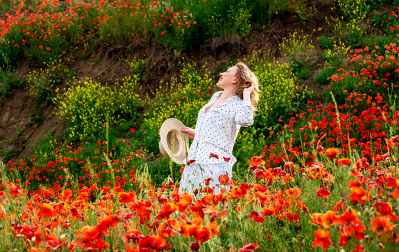 Graceful woman leans across wild poppy landscape. Pure serenity, deep earth connection.