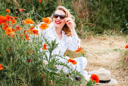 Relaxed woman rests in lush poppy field. Wellness inspiration, mindful serenity.