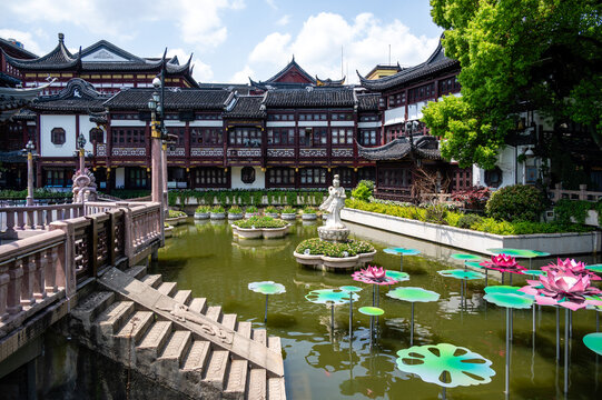 Guan Yin statue and decorative lotus flowers in the pond of Shanghai Old Town near Yu Garden, China