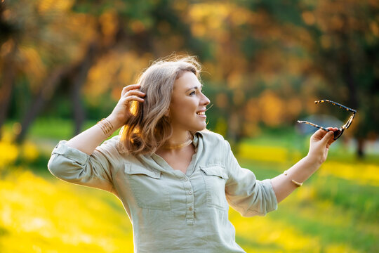 Graceful woman poses in golden light. Effortless summer charm, relaxed outdoor leisure.