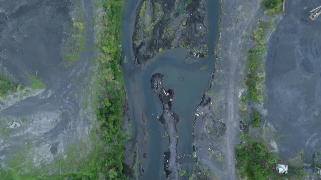 Spectacular drone view of volcanic Lahar fields and winding river near Mayon Volcano. Ideal for geology documentaries and travel productions focused on volcanic landscape.