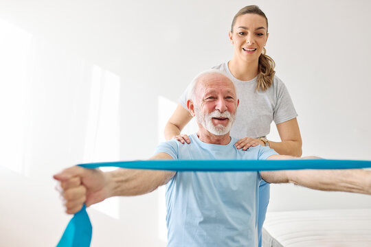 Doctor or nurse or physiotherapist caregiver exercise with senior woman at clinic or nursing home