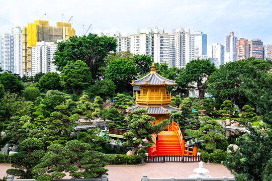Golden Pavilion of Absolute Perfection and red bridge in Nan Lian Garden contrasted with skyscrapers, Hong Kong