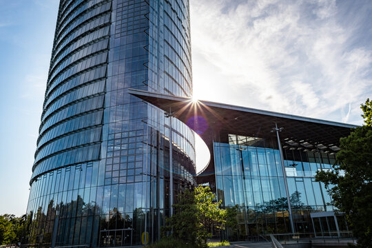 Office buildings reflect sunlight during midday in a modern business district surrounded by greenery