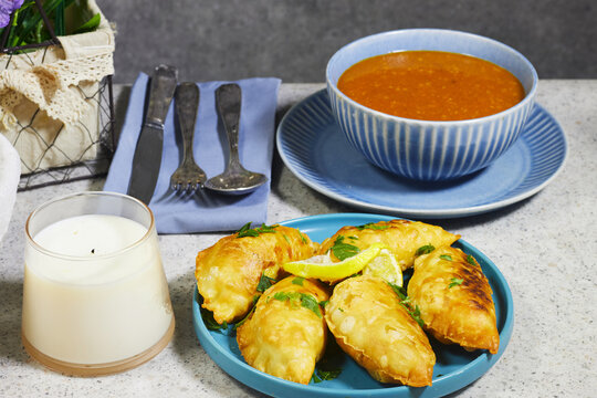 Golden Fried Empanadas With ALGERIA harira Soup, Glass of Milk and Lemon Garnish on Plate