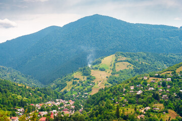 Fototapeta premium carpathian mountain landscape in summer. view in to the valley of rakhiv town near forested hill of mountain range. travel background of alpine ukraine countryside