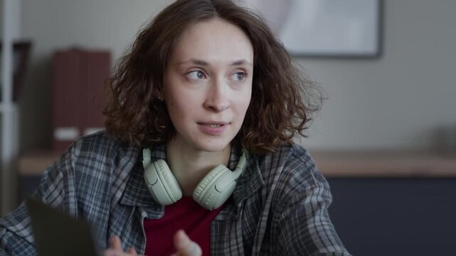 Close up of young adult Caucasian woman discussing software development with African American colleague in office, dolly in camera movement. For tech startup marketing or corporate training videos
