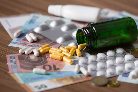 assorted medicines, blister packs, capsules and tablets scattered on euro banknotes and coins. Concept of healthcare costs, expensive medication, pharmaceutical expenses, medical insurance