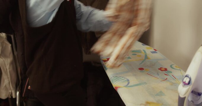 Young Woman Ironing Shirt on Ironing Board