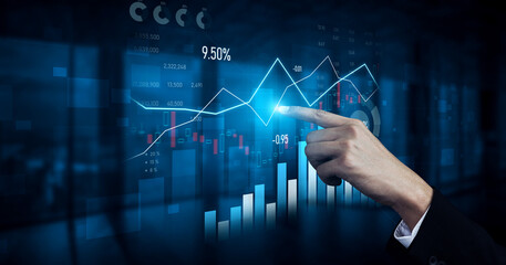 A professional examines digital data trends on a touchscreen, showcasing financial graphs and...