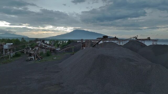 Wide aerial view of volcanic gravel quarry and conveyor plant with Mayon Volcano backdrop. Ideal for mining reports and construction industry media.