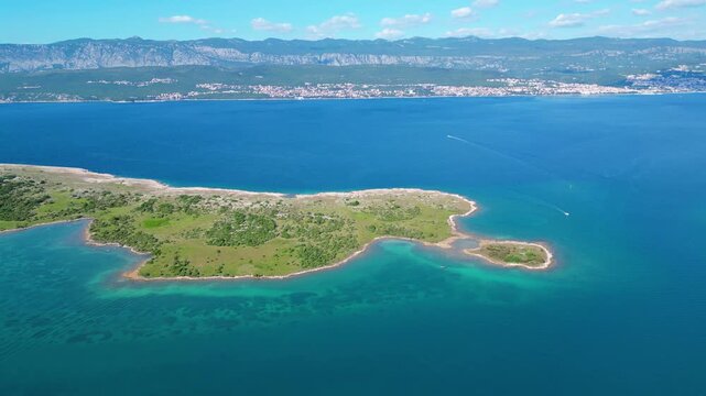 Stunning aerial view of Krk Island's lush coastline and turquoise Adriatic waters, with distant mountains and a clear sky. Perfect for summer travel. Klimno
