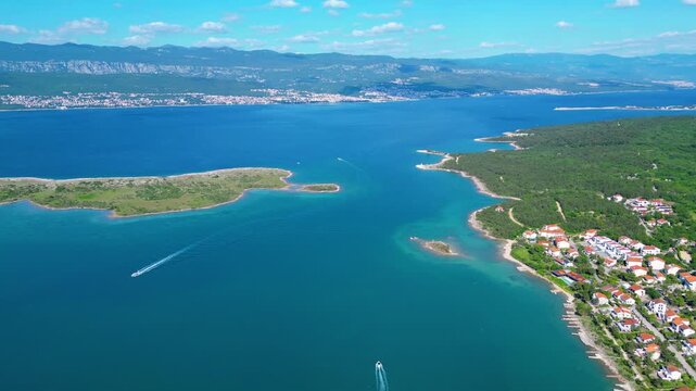 Azure waters, lush islands, and distant mountains define the stunning Croatian Adriatic. A speedboat cuts through the clear sea, inviting summer adventures. Klimno