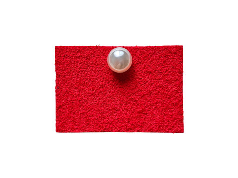 Textured red felt fabric rectangle pinned with a glossy pearl push pin on a transparent background