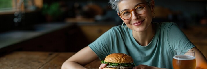 Fototapeta premium Older woman smiling while holding burger at dining table
