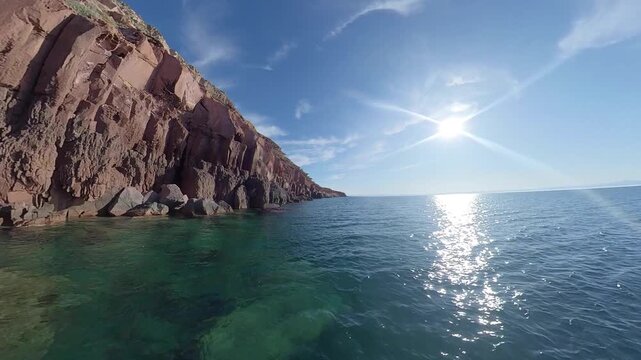 360 camera view of the dramatic cliffs of Espiritu Santo Island with crystal-clear turquoise water on a sunny day, captured in an immersive ultra wide-angle perspective.