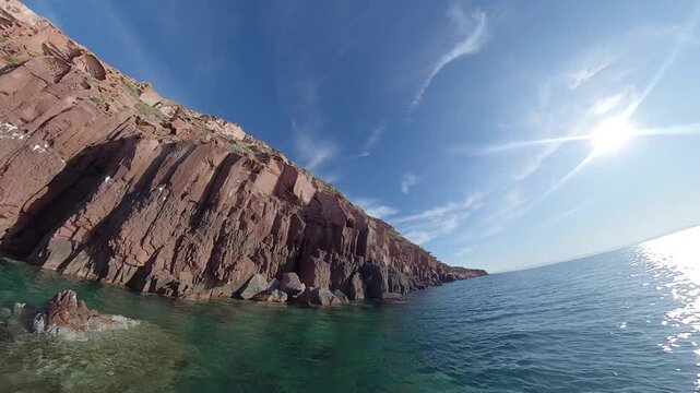 360 camera view of the dramatic cliffs of Espiritu Santo Island with crystal-clear turquoise water on a sunny day, captured in an immersive ultra wide-angle perspective.