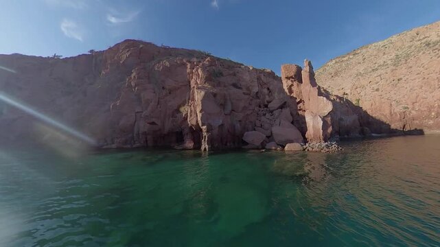 360 camera view of the dramatic cliffs of Espiritu Santo Island with crystal-clear turquoise water on a sunny day, captured in an immersive ultra wide-angle perspective.