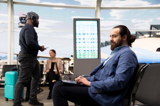Modern man working on laptop in airport departure terminal, preparing for international business meeting, corporate travel lifestyle for multinational company summit, featuring business trip.