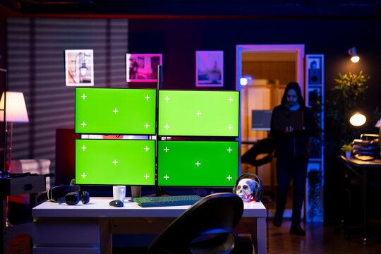 Hacker entering RGB lit apartment with mockup multi monitor setup, working on building stealth malware.