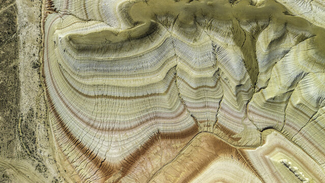 Aerial view of the vibrant multi-colored sedimentary rock layers and unique geological formations of the Kyzylkup tract, Aktau, Mangystau Region, Kazakhstan.