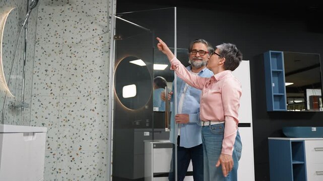 Mature couple choosing new shower stall in store