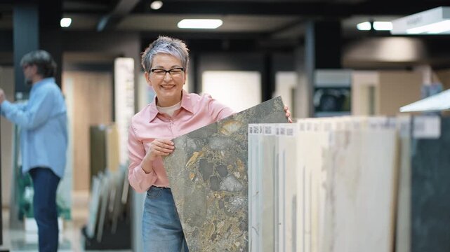 Mature woman choosing ceramic tiles for home renovation