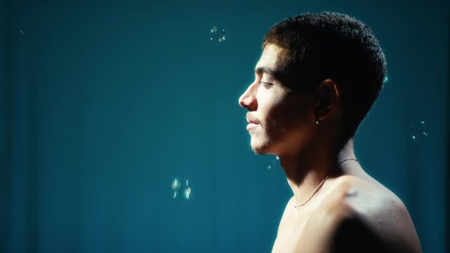 Profile portrait against blue background with rising soap bubbles