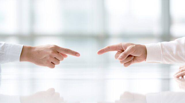 向かい合って指差す二人のビジネス対立や議論のイメージ
