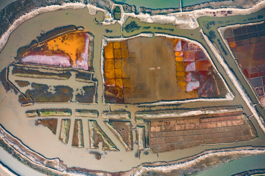 Aerial view of colorful salt evaporation ponds with geometric shapes and water channels in Cox's Bazar, Chittagong Division, Bangladesh.