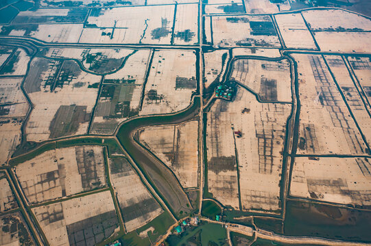 Aerial view of geometric salt pans and agricultural fields divided by narrow water canals in the rural landscape of Cox's Bazar, Chittagong Division, Bangladesh.