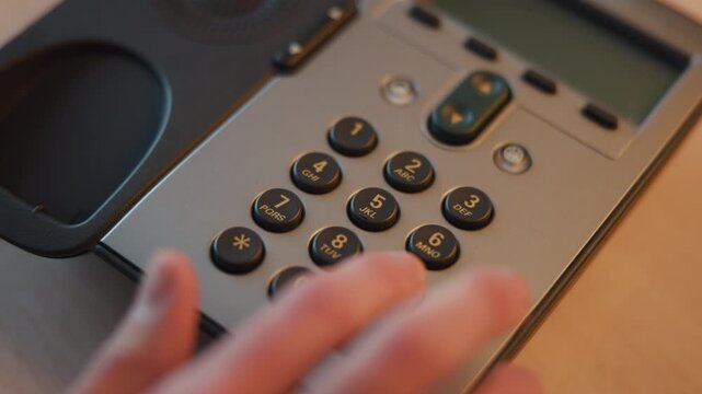 Focused Shot Of Finger Pressing Numbered Buttons On Office Telephone Keypad In Professional Environment . Media