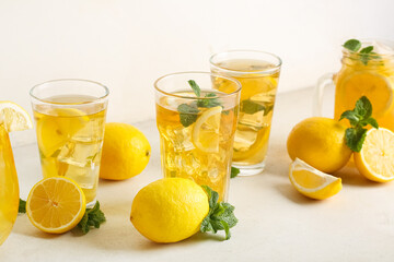 Fototapeta premium Glasses of lemon ice tea with mint and citrus fruits on white background, closeup