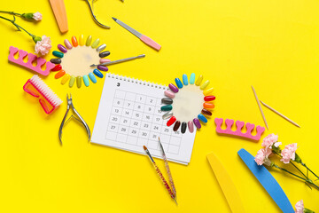 Naklejka premium Calendar with nail masters supplies and carnation flowers on yellow background