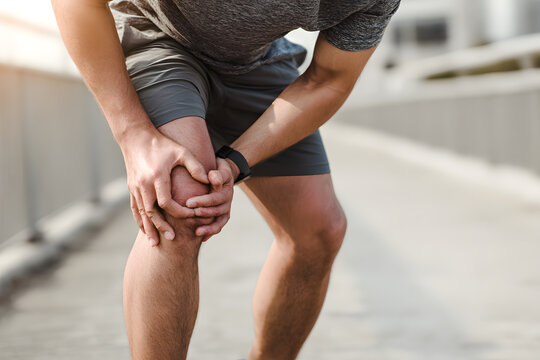 A young male runner is experiencing knee pain from an ACL injury or patellofemoral syndrome. While running, the man may experience joint aches, ligament tears, or patellar tendinitis. Sports medical a