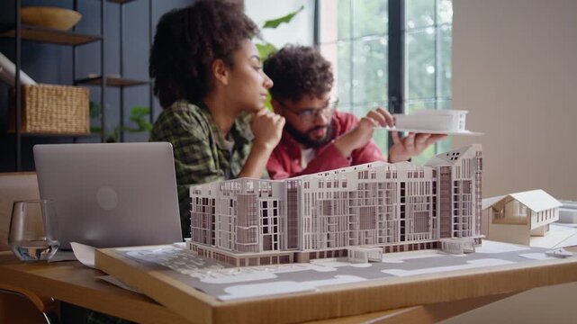 Architects study scale building models during design review