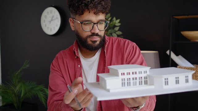 Arab architect examines mansion model facade at project review