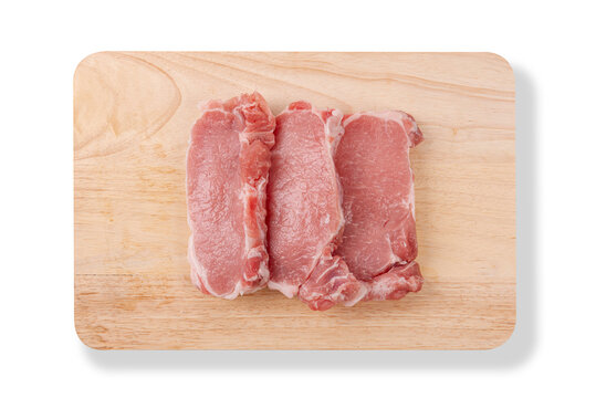 Three pieces of fresh raw pork tenderloin slices placed on wooden cutting board isolated on a white background.