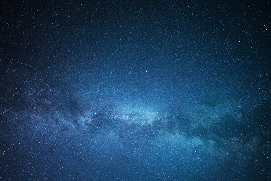 A clear, starry night with the Milky Way in the background, next to a camping tent and the rocky Canadian mountains 