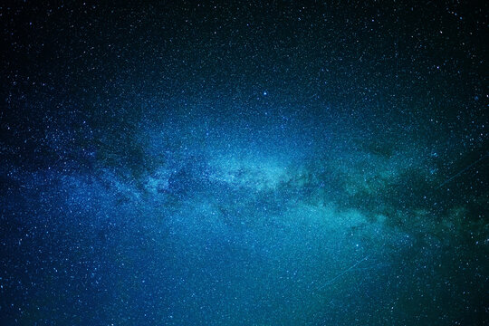 A clear, starry night with the Milky Way in the background, next to a camping tent and the rocky Canadian mountains 