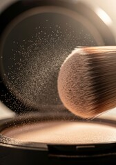 Fototapeta premium Makeup brush hitting pressed face powder with floating dust particles. Cosmetic product demonstration for beauty blog. Professional accessory for applying foundation and base makeup.