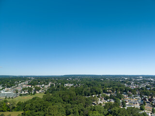Obraz premium Suburban neighborhood with houses and green trees under clear blue sky