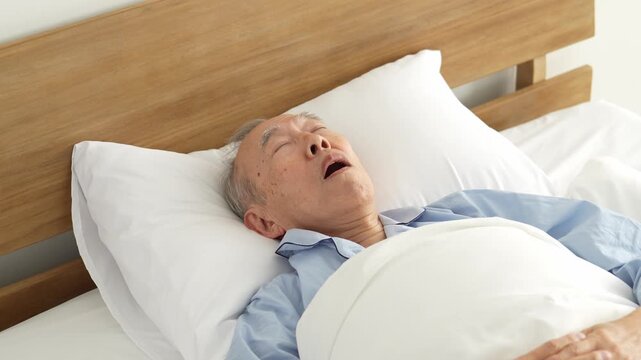ベッドで眠る口呼吸の高齢者の男性