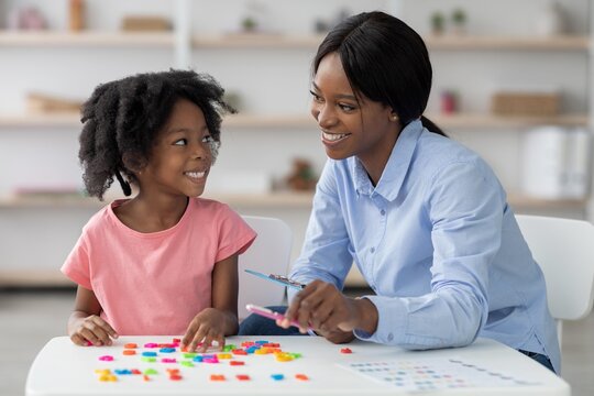 Smiling Black Mother With Daughter Playing Together With Colorful Building Blocks At Home, Encouraging Creativity And Bonding In A Cheerful Atmosphere. Family Lifestyle Concept.