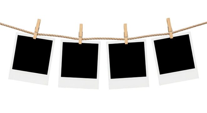 Four empty polaroid frames hanging on a wooden clothesline isolated on transparent background