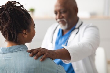 Fototapeta premium Caring And Supportive Doctor Showing Empathy To Black Female Patient During Consultation In Healthcare Clinic, Building Trust And Open Communication In Professional Setting. Healthcare Concept.