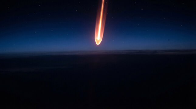 Glowing Space Capsule Reentry Vehicle Falling Deep in Earth Atmosphere with Burning Orange Plasma Trail over Dark Horizons at Night, Spaceship Return Mission or Falling Meteorite Comet Astronomy