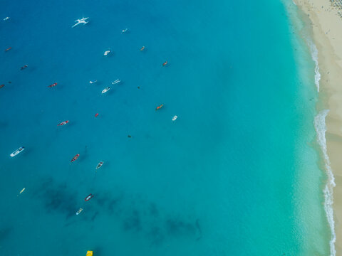Aerial view of turquoise waters and small boats anchored near the sandy beach of Santa Maria, Sal, Cabo Verde.